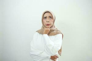 Portrait of thinking young Asian woman looking up and touch chin isolated on over white background photo