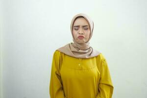 A portrait of a shocked Asian woman wearing a mustard casual dress duck face expression, isolated by a white background photo