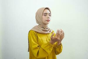 Portrait of Asian Muslim woman praying with open arm isolated over white background photo