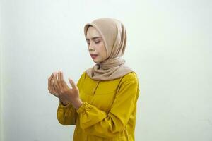 Portrait of Asian Muslim woman praying with open arm isolated over white background photo