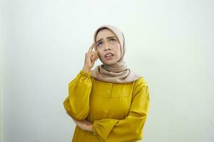 Portrait of thinking young Asian woman looking up and touch chin isolated on over white background photo