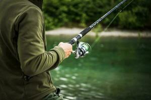 Caucasian Fisherman with His Rod. Recreation Theme. Evening Time Fly Fishing in Norway. photo