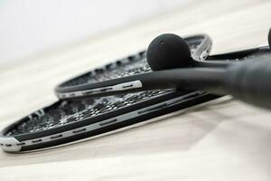 Squash Rockets and a Ball on a Court Floor Close Up Photo. photo