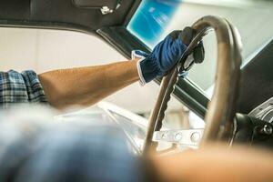 Restoration Mechanic Behind Classic Car Steering Wheel photo