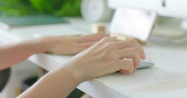 Close-up of asian woman hands white skin using computer mouse and keyboard to search for information. Office girl is sitting and working in the office. 4K video. pc software apps technology concept. video