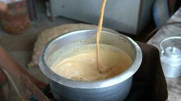 Indien bord de la route chaud Lait thé chai wala thé vendeur mélange lait, sucre, et chai patti à faire le meilleur traditionnel Indien thé. video