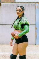 Portrait of mexican woman american football player wearing uniform with velociraptor skin patterns photo