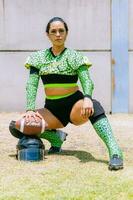 Portrait of mexican woman american football player wearing uniform with velociraptor skin patterns photo
