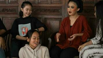 un' gruppo di indonesiano donne siamo chat con loro amici nel un' tradizionale Casa video