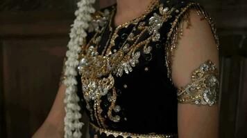 details of the bride's dress in sparkling gold and black and orange video