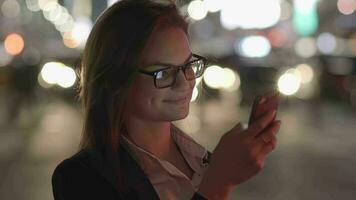 ung självsäker kvinna använder sig av mobil smart telefon enhet i de stad video