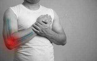 Close up a man holding hands. Pain in the elbow broken. The hearth and swelling is highlighted in red. Close up. Isolated on white background.Medical healthcare concept. photo