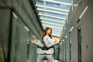 Young woman working on digital tablet in the office hallway photo