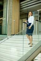 Yyoung business woman walking on stairs in the office hallway photo