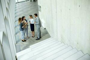 Young startup team have a discussion by stairs in the office corridor photo