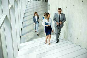 Young startup team have a discussion while climbing on  stairs in the office corridor photo