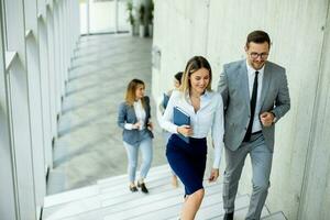 Young startup team have a discussion while climbing on  stairs in the office corridor photo