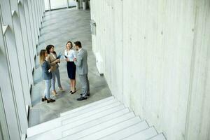 Young startup team have a discussion by stairs in the office corridor photo