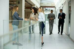 Three young business women having a discussion in the office hallway photo