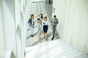 Young startup team have a discussion while climbing on  stairs in the office corridor photo