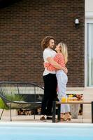 Young couple relaxing by the swimming pool in the house backyard photo