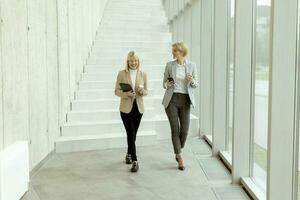 Business women walking in the office corridor photo