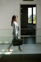 Young business woman walking with briefcase in the office hallway photo