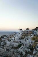 Oia village on Santorini island in Greece at sunset photo