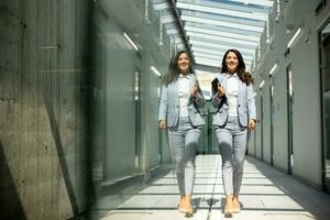 Young woman walking with digital tablet in the office hallway photo