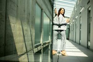 Young woman working on digital tablet in the office hallway photo