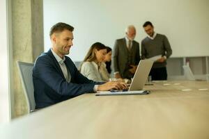 Young business man using laptop computer in the office photo