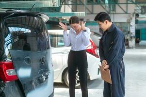 A young Caucasian woman complains to mechanic man about service to repair her car feeling upset repair service photo