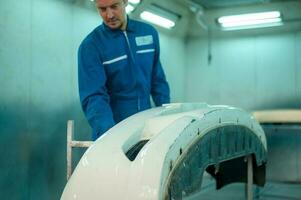 close up Caucasian man hand cleaning car part before painting  in paint shop photo