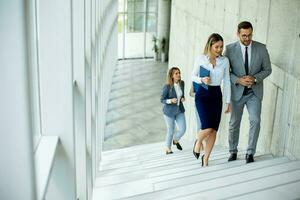 Young startup team have a discussion while climbing on  stairs in the office corridor photo