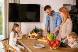 Young family preparing vegetables in the kitchen photo