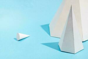 paper pyramids close up and lying cone top on blue photo