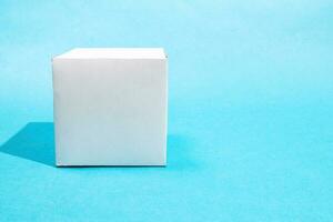 front view of hand-crafted paper cube on blue photo