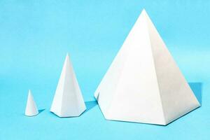 handmade various paper cone and pyramids on blue photo