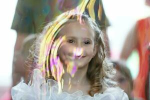 03 June 2016 Belarus, the city of Gomil. Kindergarten in the city. Little girl at matins in a soap bubble. photo