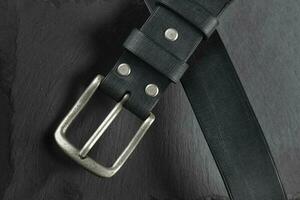 Black leather belt on a dark background. Leather products. photo