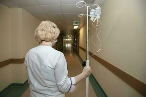 The doctor carries a dropper along the corridor of the hospital. photo