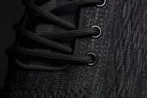 The texture of a black rag sneaker with laces close-up. photo
