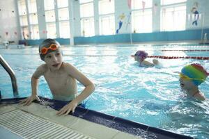 Children in swimming caps and goggles in the sports pool. photo