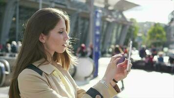 une femme est en utilisant sa cellule téléphone tablette tandis que permanent dans le rue video