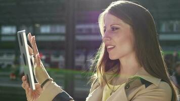 een vrouw is gebruik makend van haar cel telefoon tablet terwijl staand in de straat video