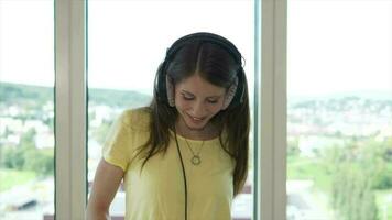 jovem feliz mulher dançando alegre ouvindo para música vestindo fones de ouvido dentro apartamento video
