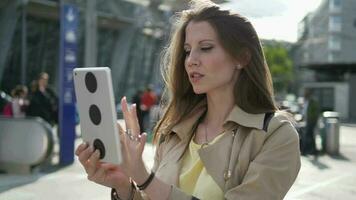 joven confidente mujer utilizando móvil tableta dispositivo en negocio viaje video