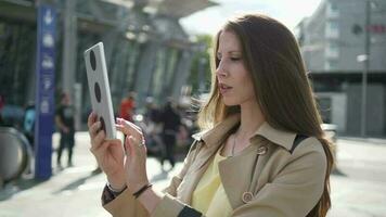 a woman is using her cell phone tablet while standing in the street video