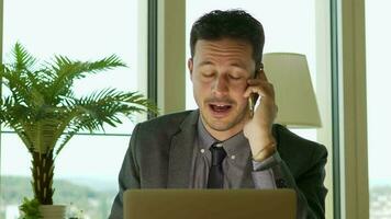 a man in a suit and tie sitting at a desk with a lap working in finance business jobtop video