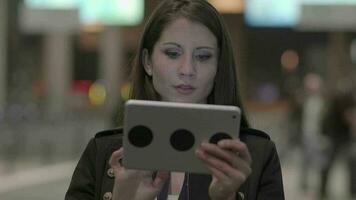 Young confident woman using mobile tablet device on business trip video